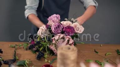 一位年轻的花店助理用丝带绑着一束花躺在她的桌子上的肖像。 慢镜头
